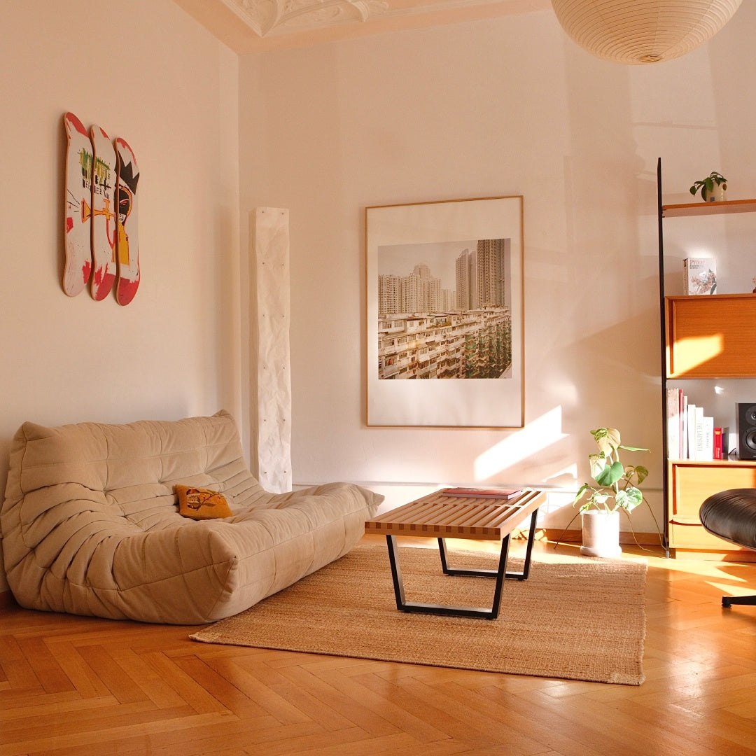 Jean-Michel Basquiat "Trumpet" skateboard wall art by THE SKATEROOM in a japandi interior apartment, above a Ligne-Roset Togo couch
