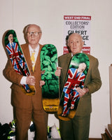 Gilbert & George holding their "The Nettle Dance" skateboard triptych by THE SKATEROOM in their London Studio.