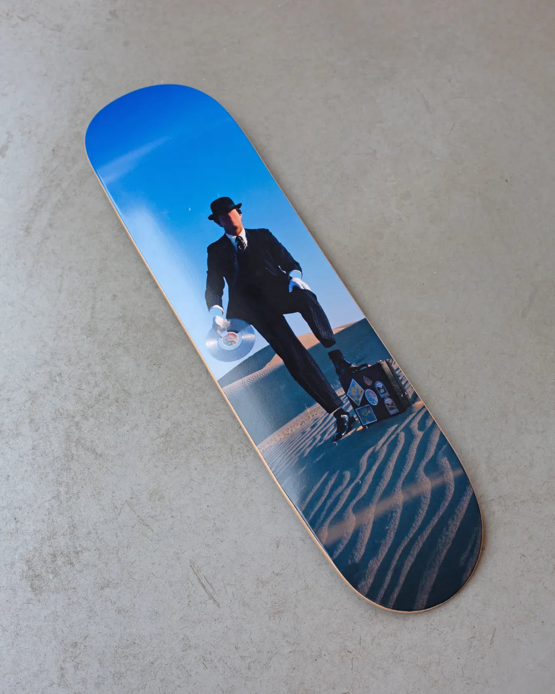 Skate deck with the Invisible Man artwork by Pink Floyd, produced by THE SKATEROOM, on a concrete floor.
