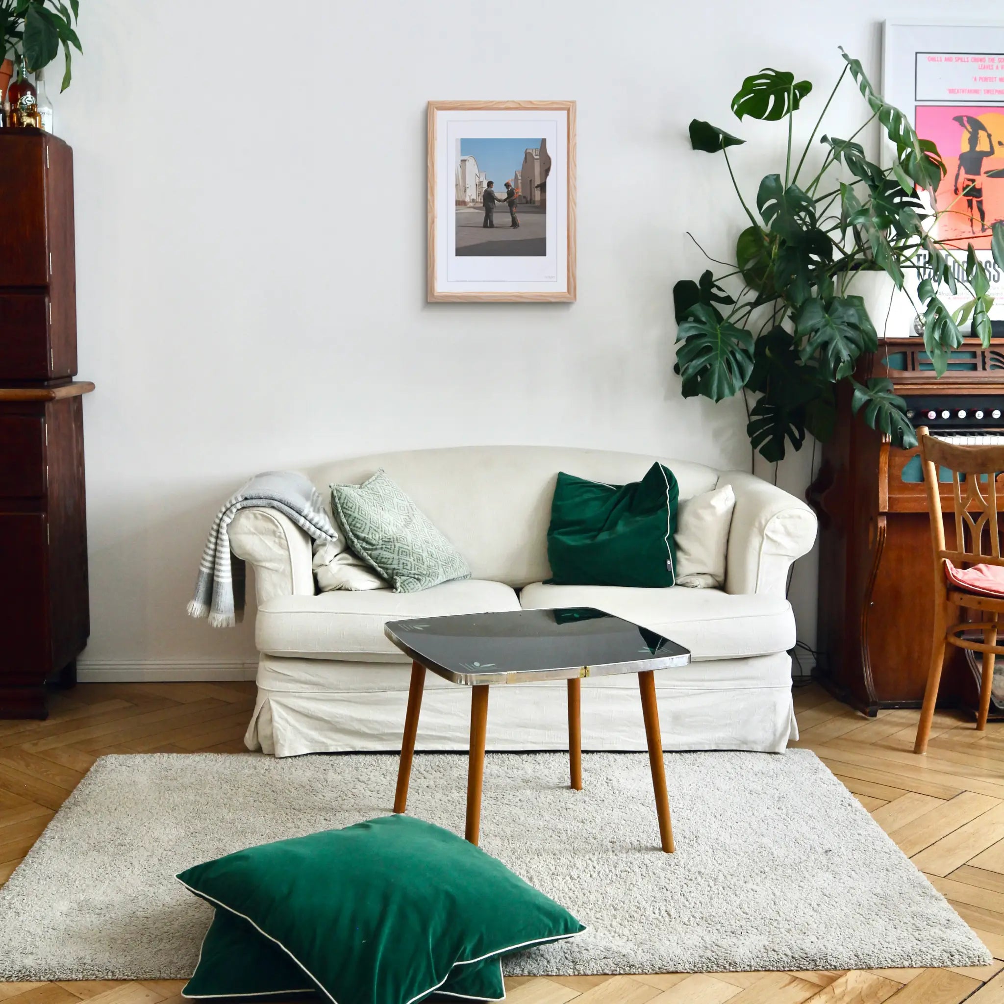 Living room with a white sofa, green cushions, and a coffee table, and the giclée print Wish You Were Here by Pink Floyd and THE SKATEROOM hanging on the wall in a frame.