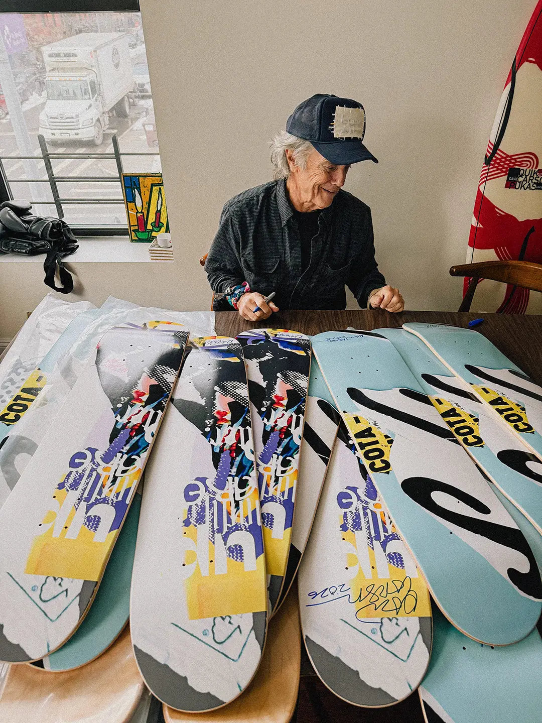 Artist and graphic designer David Carson hand signing limited edition skate decks.