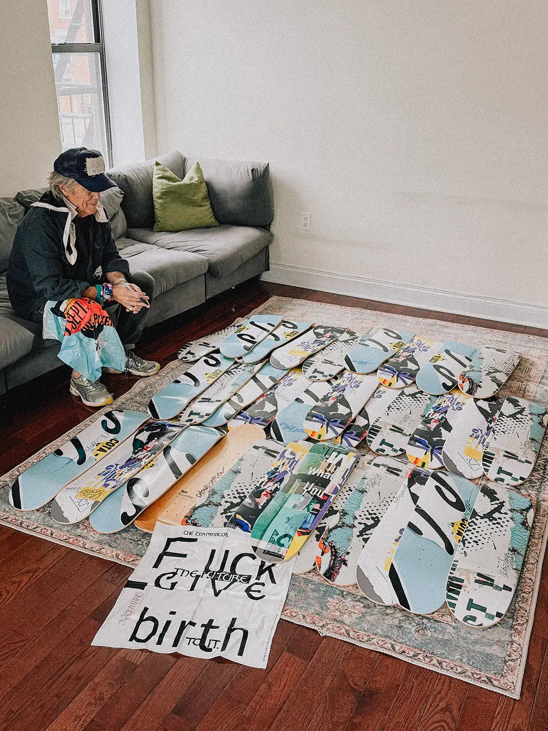 Artist David Carson sitting next to his limited editions collection of skate decks with THE SKATEROOM.