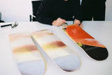 Artist Luc Tuymans hand-signing skate decks.