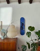 Stylish living room with the Henri Matisse 'Icare - Plate 8 of Jazz' skate deck elegantly displayed on the wall, complementing mid-century modern decor and lush greenery.