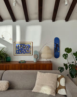 Stylish living room with the Henri Matisse 'Icare - Plate 8 of Jazz' skate deck elegantly displayed on the wall, complementing mid-century modern decor and lush greenery.