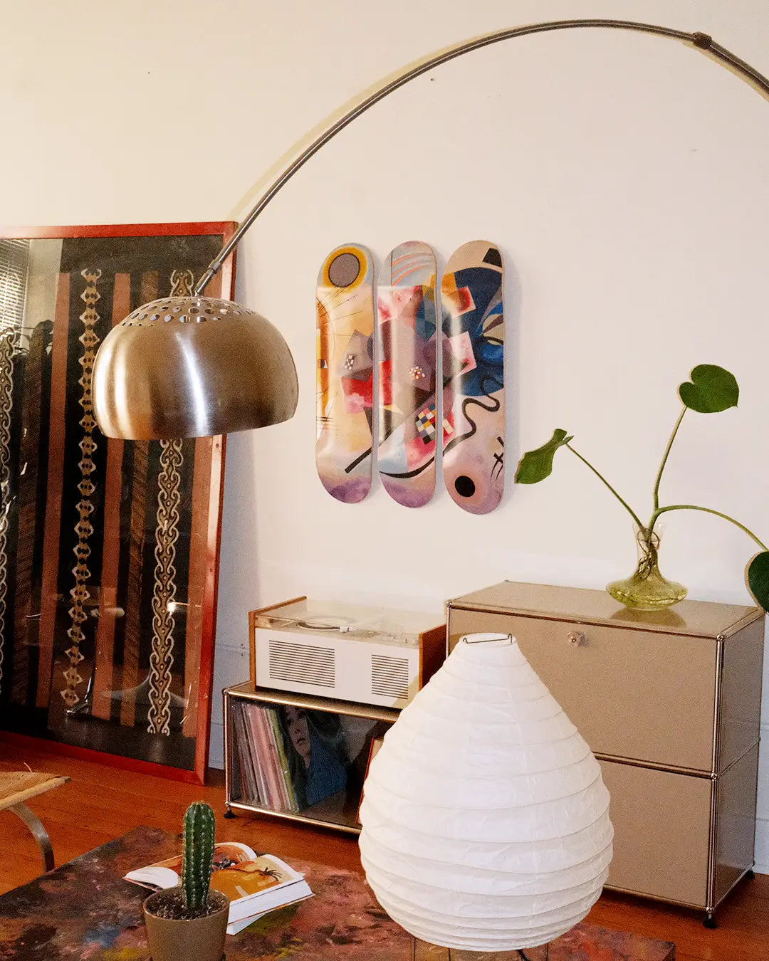 Living room with decorative elements including a lamp, vase, and a skate triptych by Wassily Kandinsky.