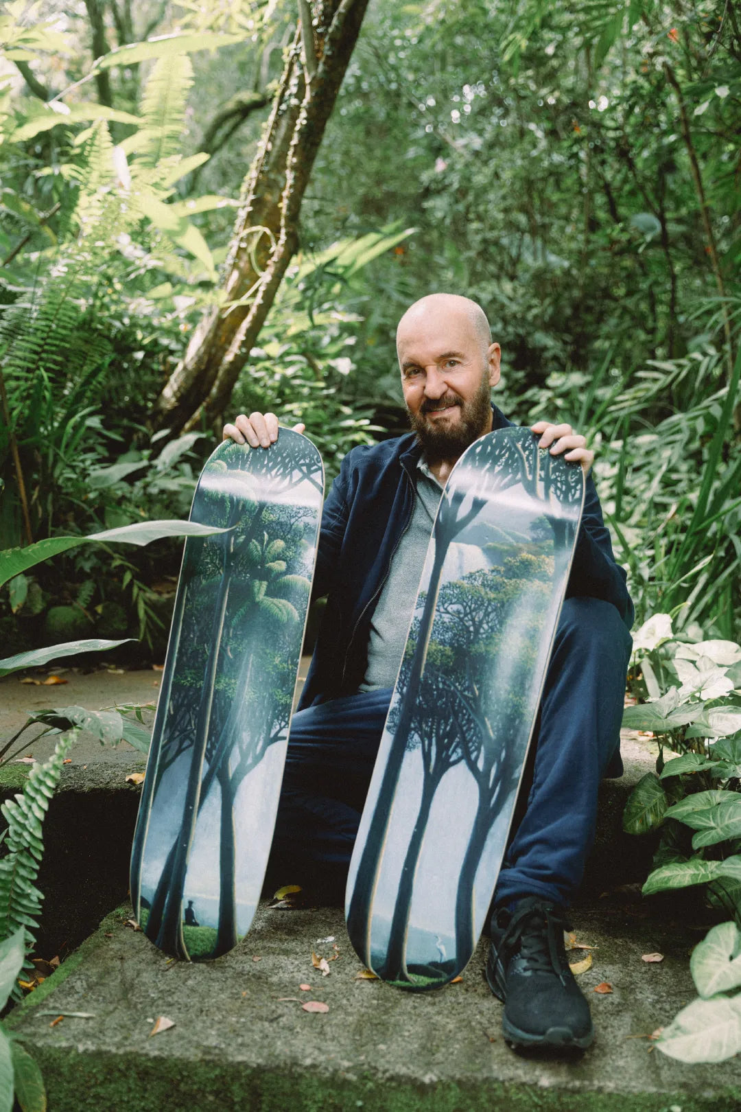 Tomas Sanchez holding two skateboard decks limited editions in a jungle setting