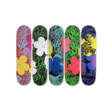 Five colorful skateboard decks with floral and abstract designs by Andy Warhol and THE SKATEROOM.