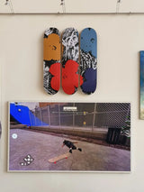 Andy warhol skate decks triptych by THE SKATEROOM, hanging on a wall above a TV.