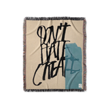 Beige woven blanket with black text and blue graphic, artwork by american artist David Carson. Perfect art gift for design fans.