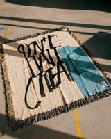 Textile with 'Don't Hate, Create' printed on it, laid flat on a surface.