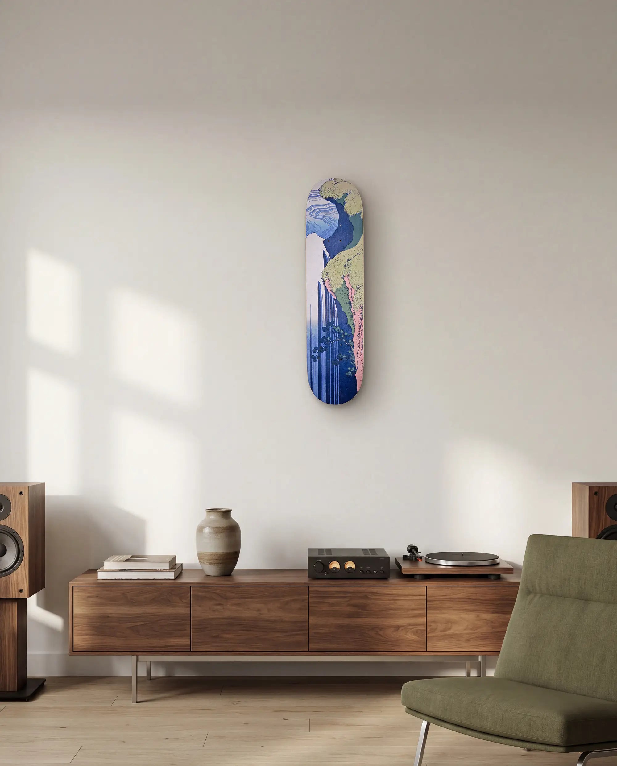 Decorative skateboard by Hokusai and THE SKATEROOM on a wall above a wooden console table in a living room.