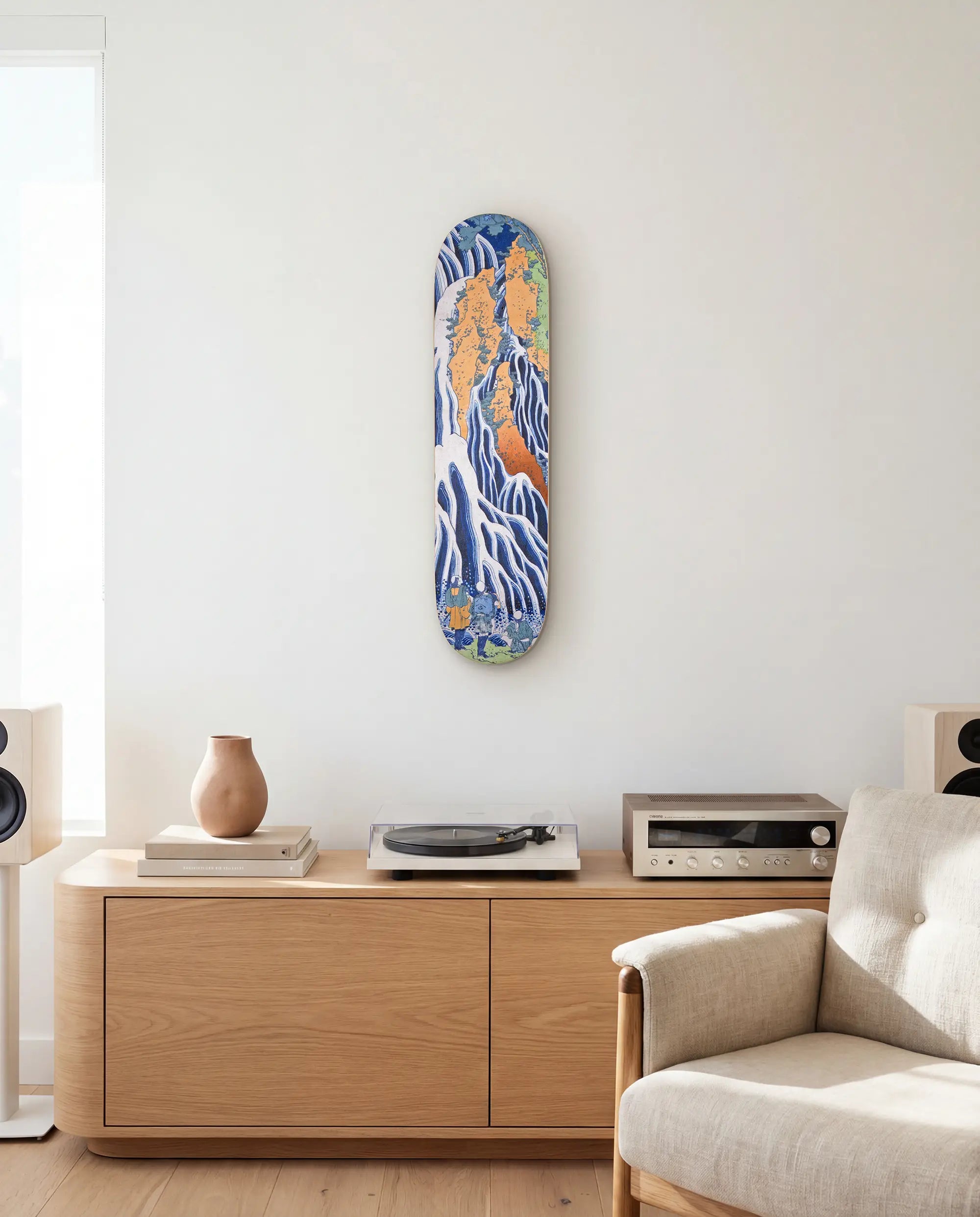 Decorative skateboard on a wall above a wooden console table in a living room.