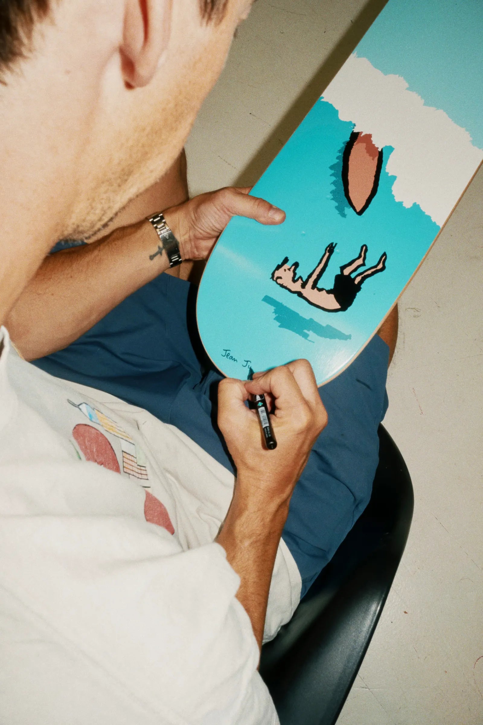 Jean Jullien hand-signing Cooking art skateboard for The Skateroom — each edition individually signed by the artist