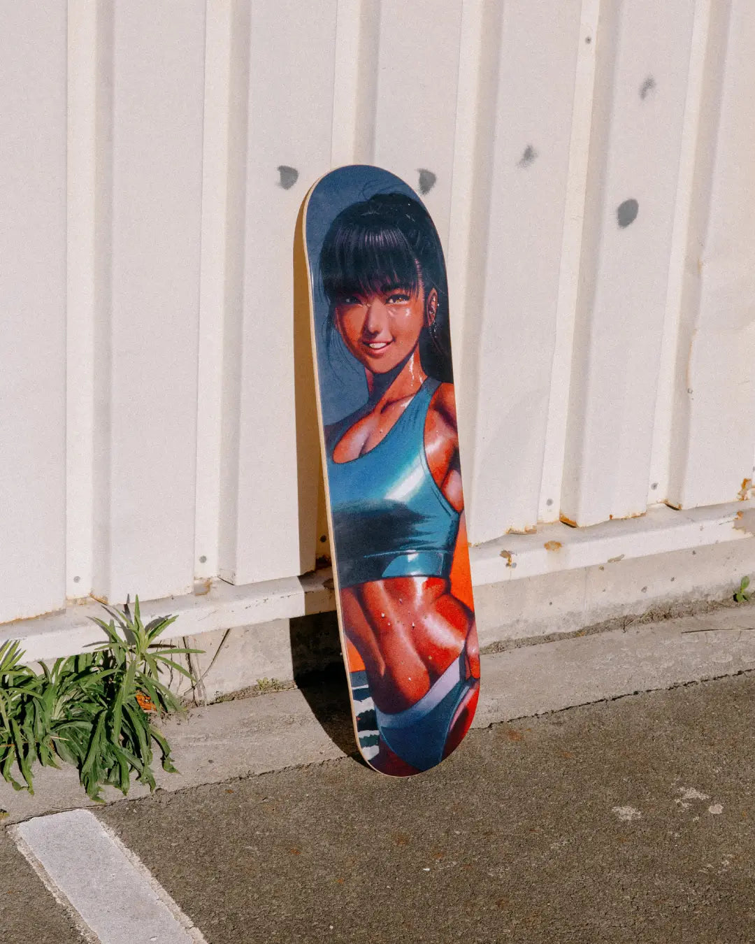 Burning Like a Star art skateboard by Little Thunder leaning against a white corrugated wall outdoors