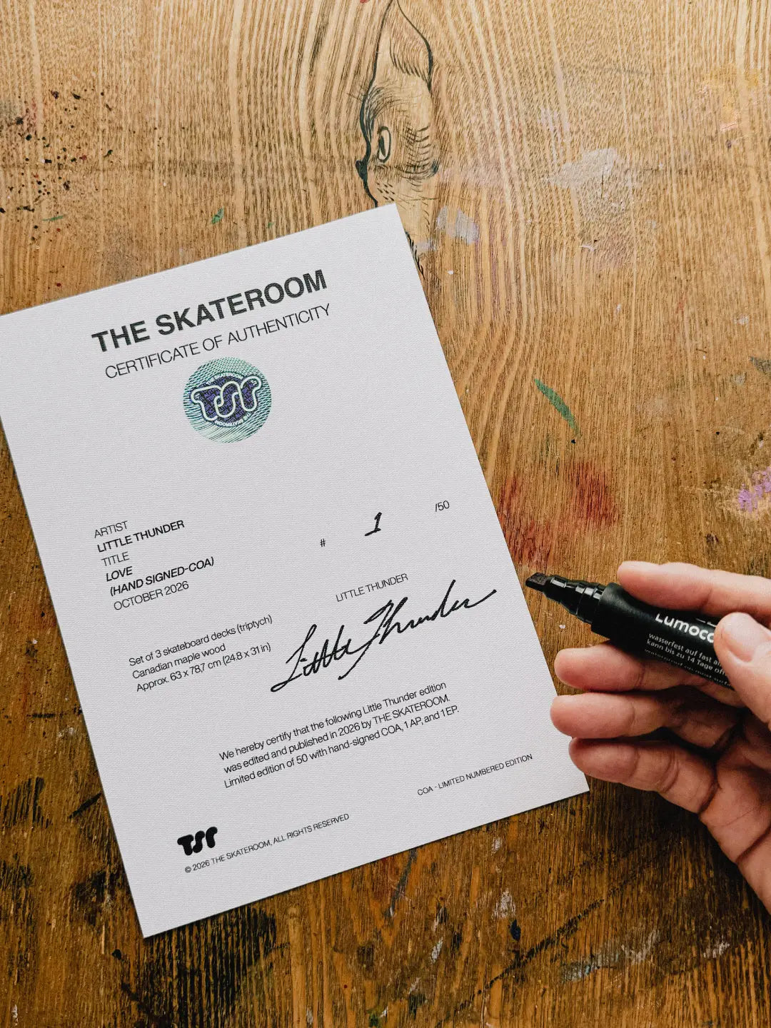 Little Thunder hand-signing a THE SKATEROOM certificate of authenticity