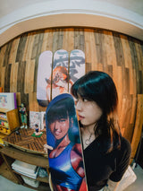 Artist Little Thunder holding her Burning Like a Star skateboard deck
