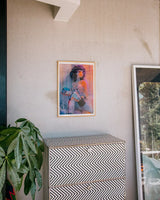 Framed Whirlwind art print by Little Thunder hanging above a dresser in a bright interior