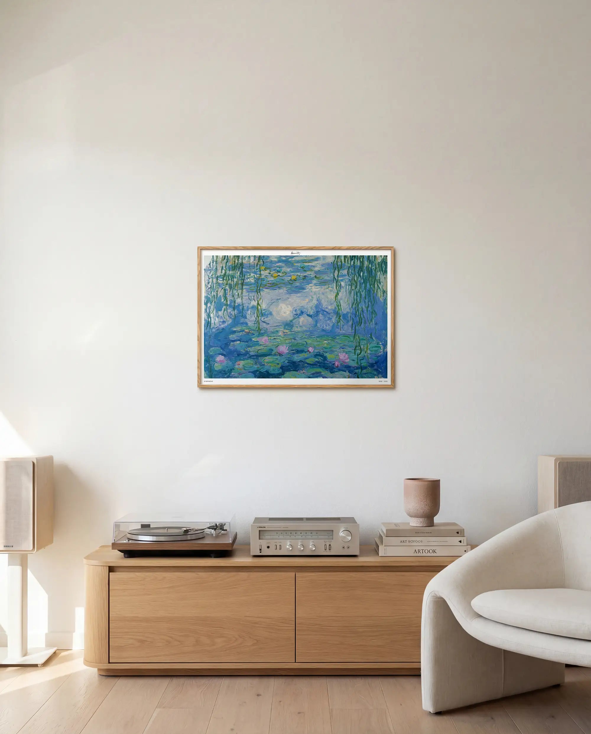 Framed artwork on a wall above a wooden cabinet in a living room.