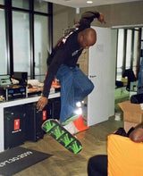 virgil abloh captured while launching a kickflip with a louis vuitton skate deck